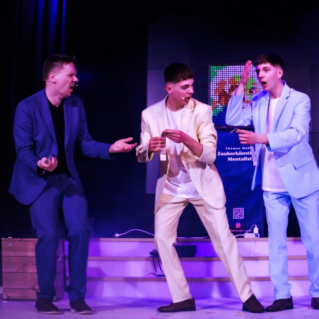 Thomas Majka, Merlin und Benito ziehen Grimassen auf der Bühne während einer Zaubershow